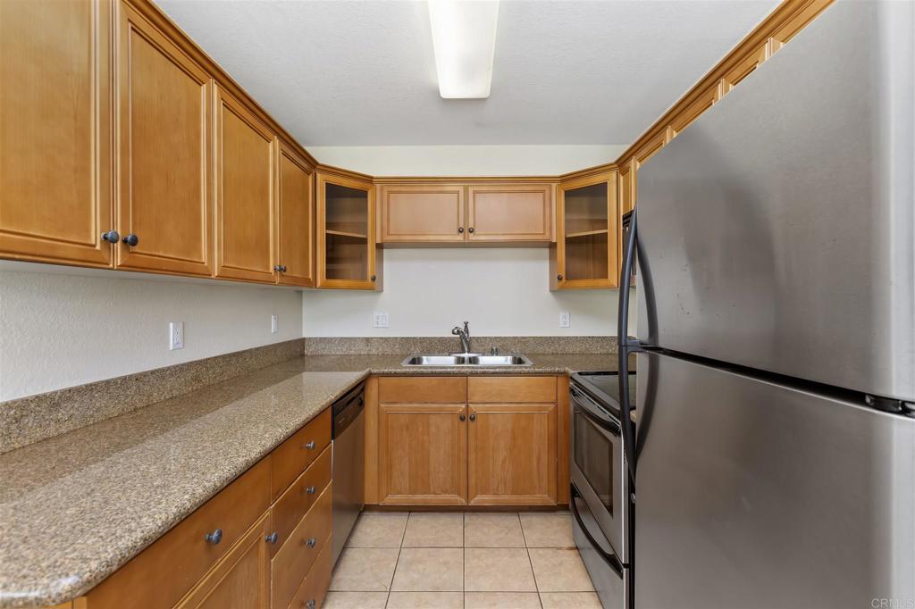 6602 Beadnell Way, Unit 26 San Diego, CA 92117 - Photo 15 of 25 a kitchen with stainless steel appliances granite countertop a sink stove and refrigerator