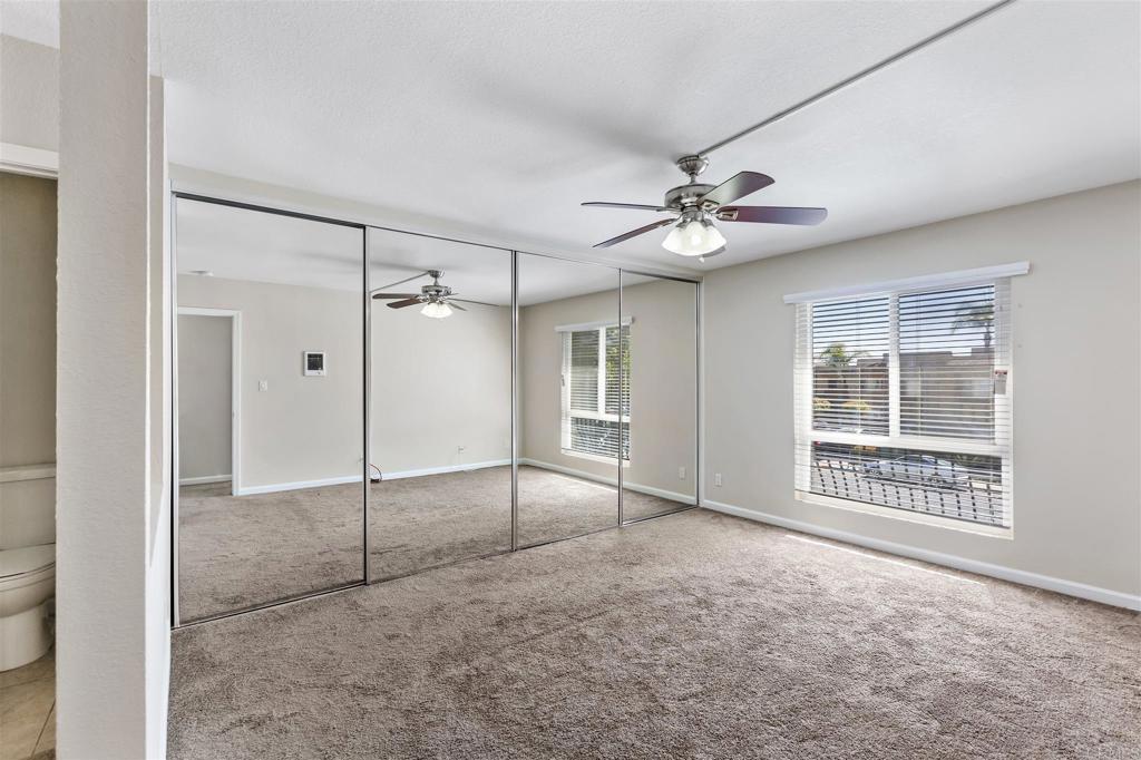 6602 Beadnell Way, Unit 26 San Diego, CA 92117 - Photo 19 of 25 a view of an empty room with a ceiling fan and windows