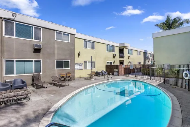 a view of a kitchen with kitchen island stainless steel appliances a sink and living room view