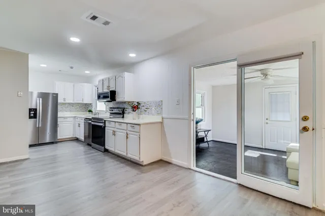 a kitchen with white cabinets and stainless steel appliances