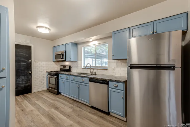 a kitchen with stainless steel appliances granite countertop a refrigerator and a sink