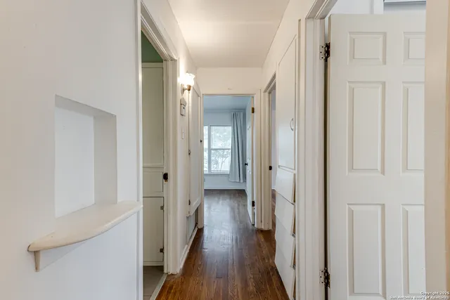 a view of a hallway with wooden floor