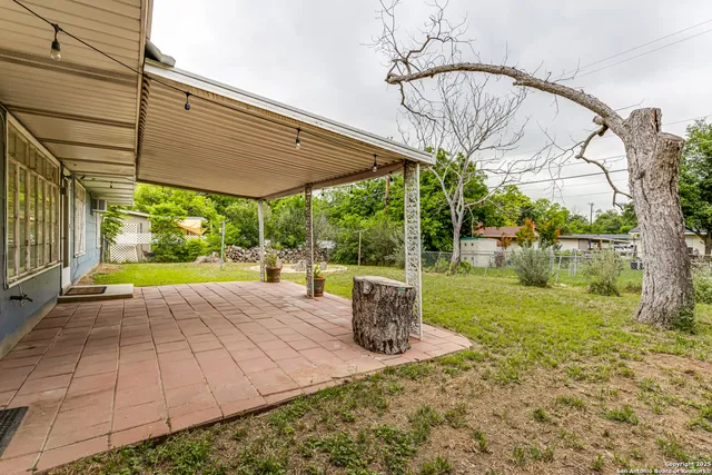 a view of a wooden house with a yard and sitting area