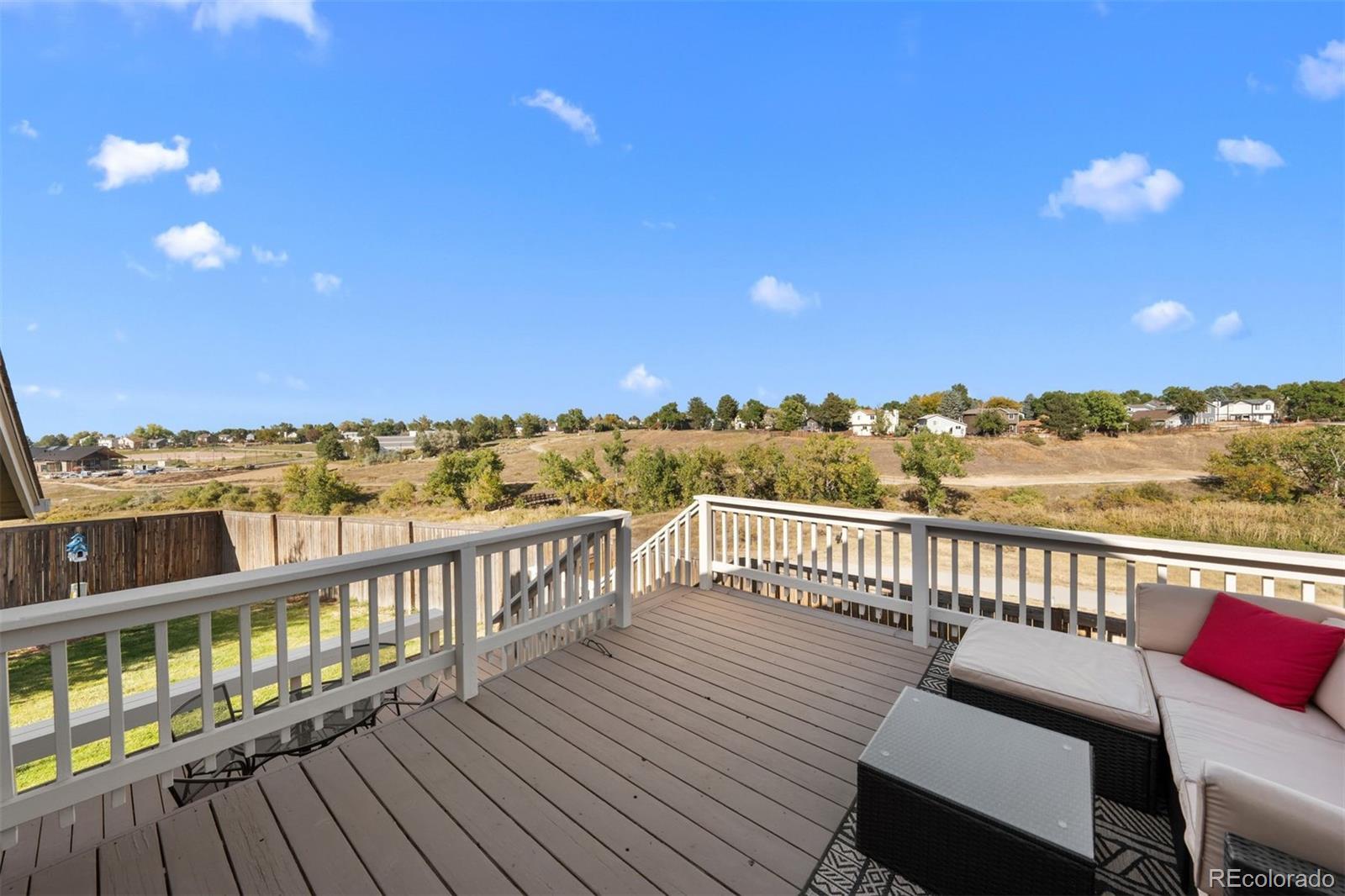 9428 Pendleton Drive Highlands Ranch, CO 80126 - Photo 12 of 16 a view of a balcony with wooden floor and city view