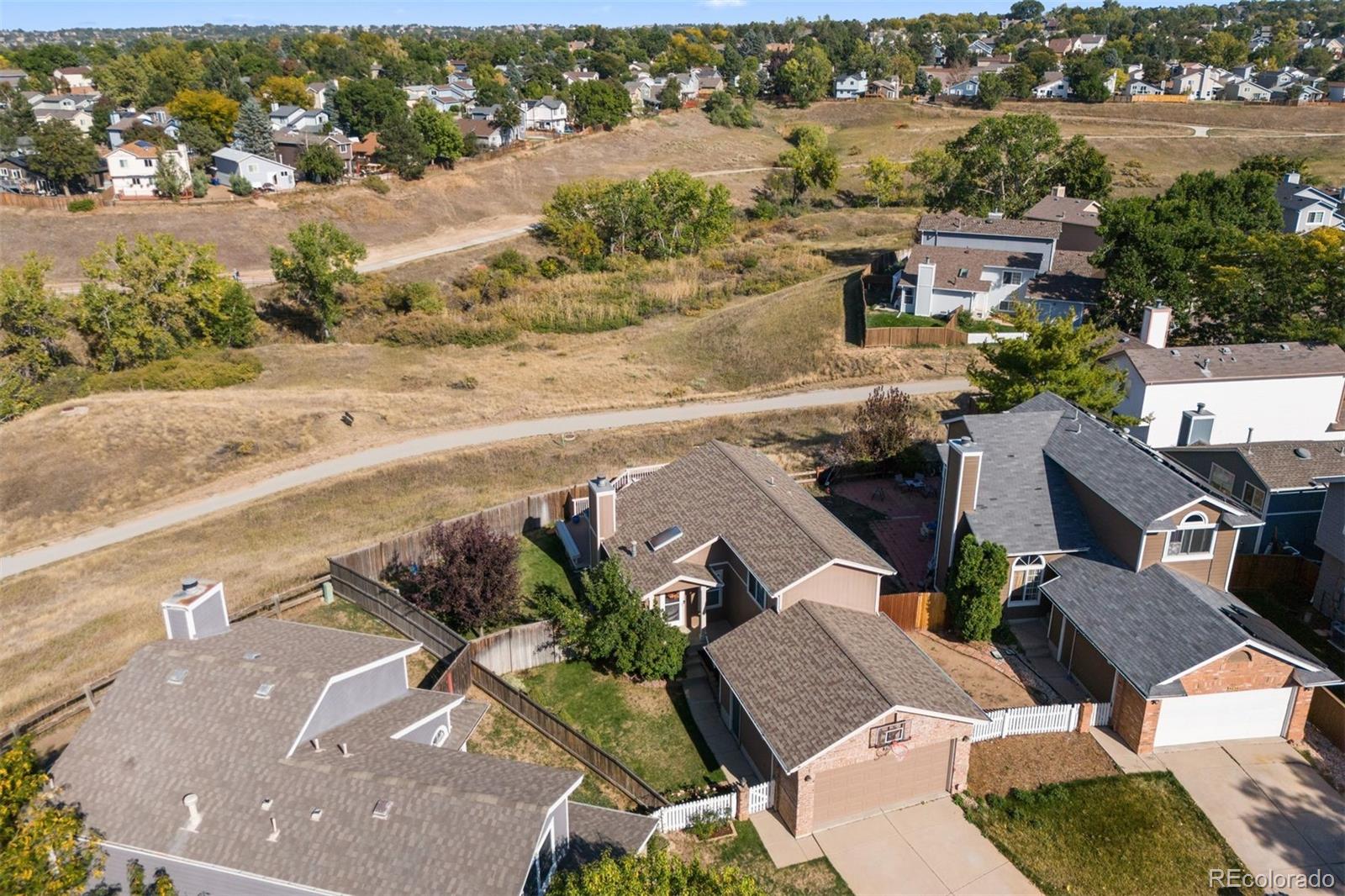 9428 Pendleton Drive Highlands Ranch, CO 80126 - Photo 16 of 16 an aerial view of a house with a yard and lake view