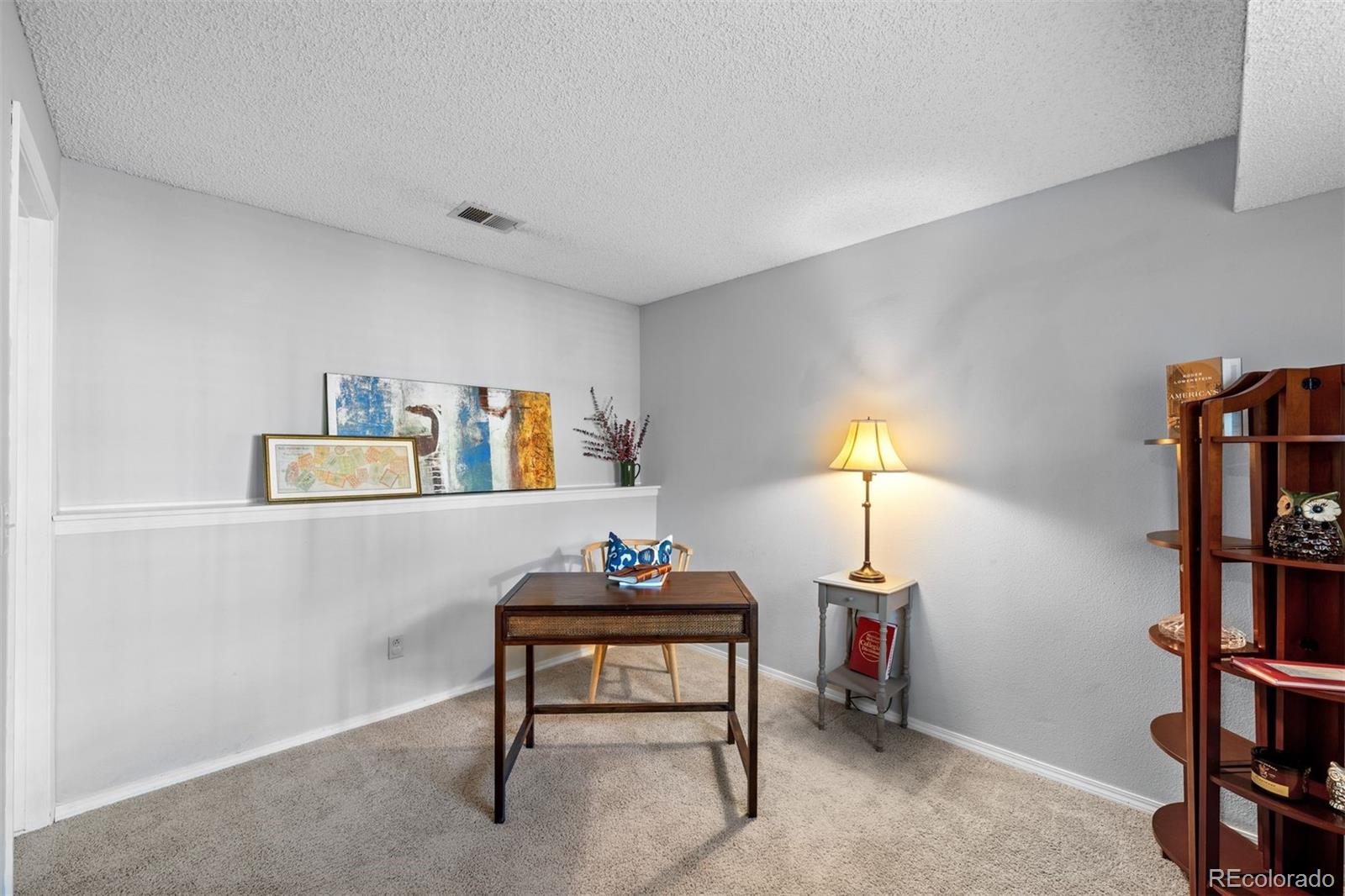 9428 Pendleton Drive Highlands Ranch, CO 80126 - Photo 9 of 16 a room with furniture and a book shelf