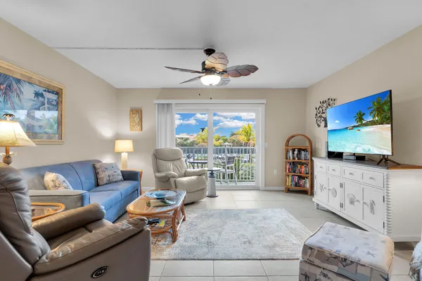 a living room with furniture a chandelier and a flat screen tv