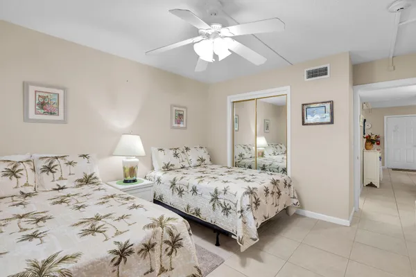 a bedroom with two bed and a lamp