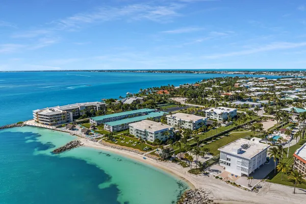 an aerial view of a city with lots of residential buildings ocean and mountain view in back