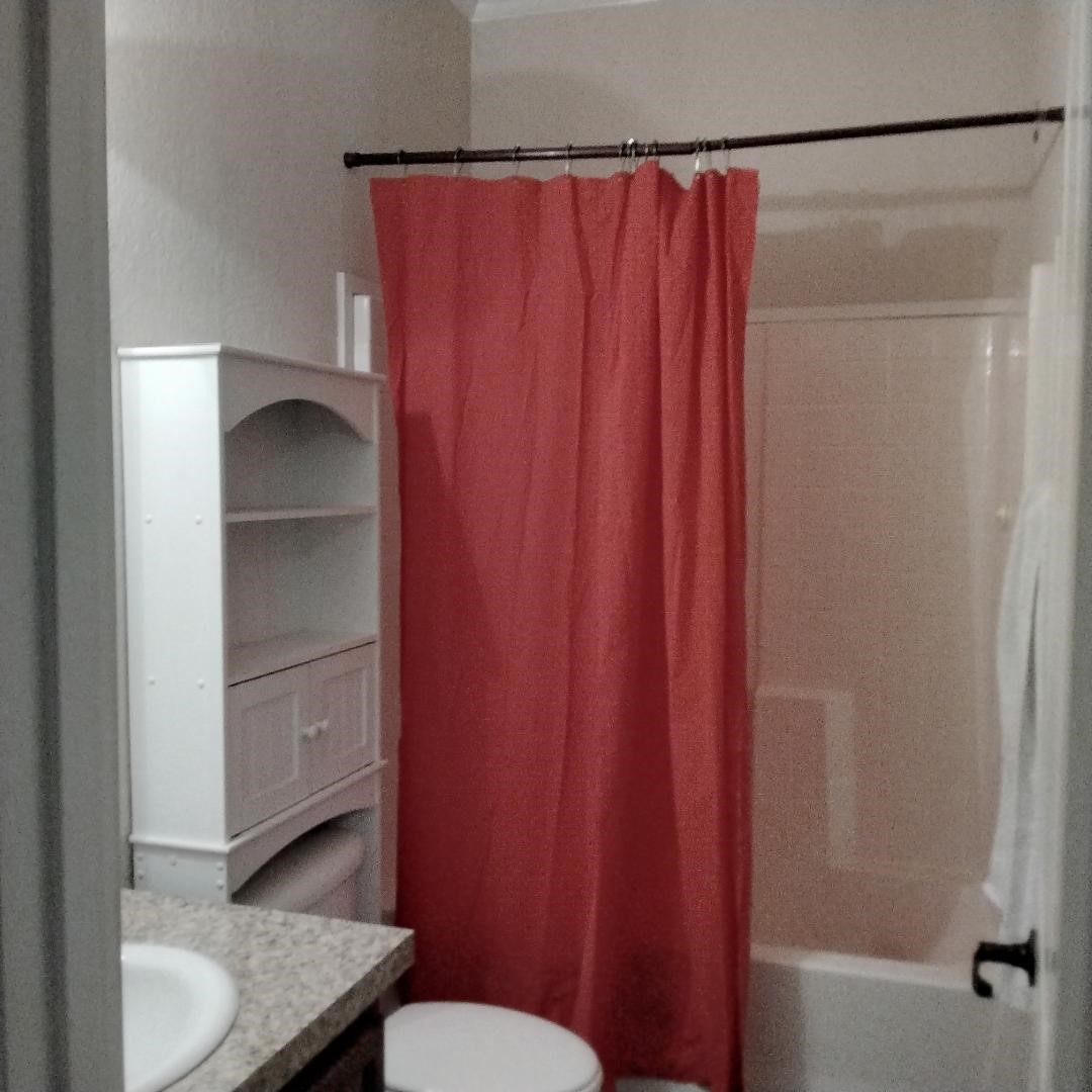 427 County Road 4822 Timpson, TX 75975 - Photo 12 of 23 a bathroom with a shower curtain and a toilet