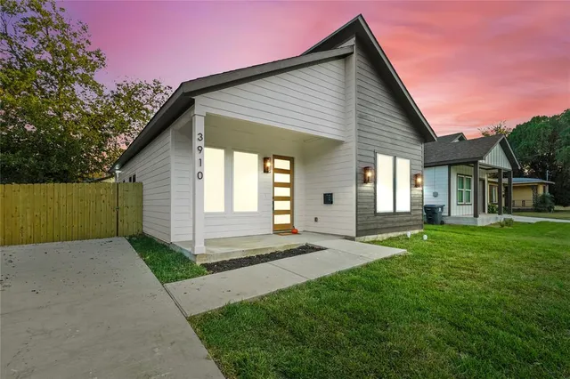 a front view of a house with a garden and yard