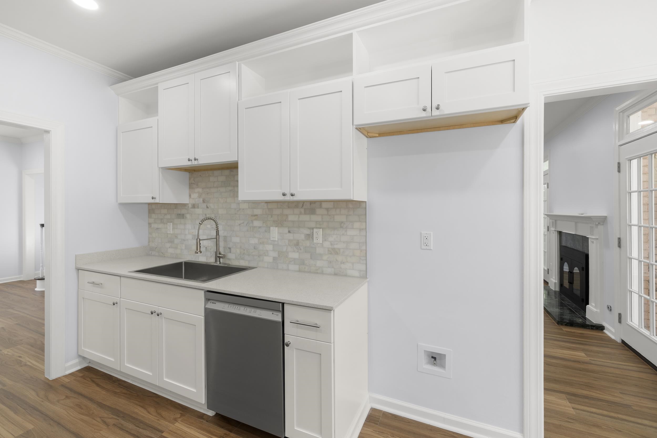 486 Brook Ridge Circle Memphis, TN 38018 - Photo 22 of 40 Kitchen featuring white cabinets, dishwasher, dark wood-style floors, backsplash, and crown molding