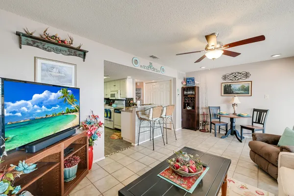 a living room with furniture a flat screen tv and a dining table