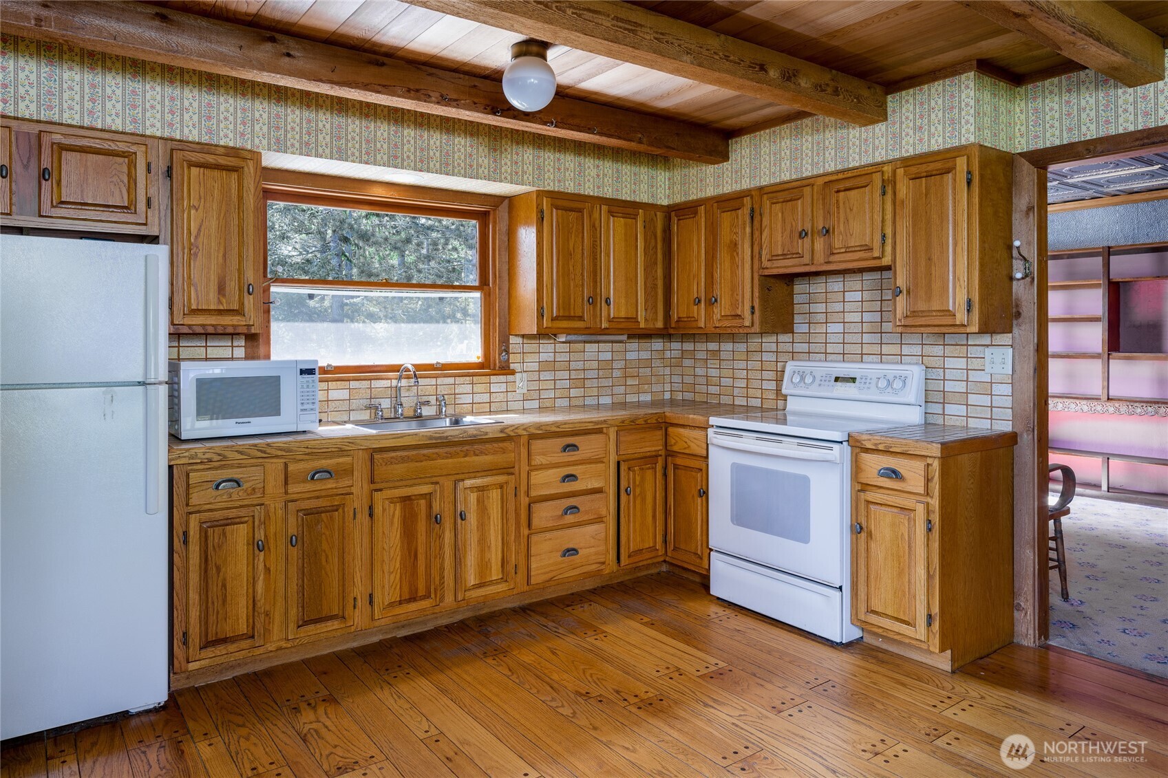 208 Tides End Road Lopez Island, WA 98261 - Photo 14 of 40 a kitchen with stainless steel appliances granite countertop wooden cabinets a sink and dishwasher with wooden floor