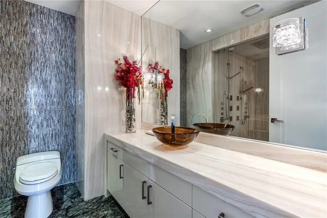 a kitchen with kitchen island granite countertop a sink a stove and cabinets