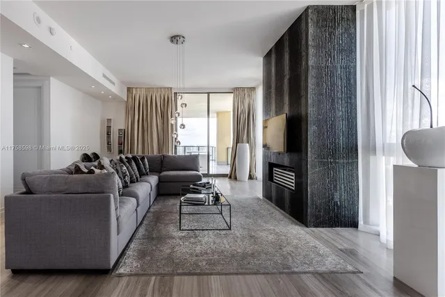 a bedroom with a large bed a fireplace and windows