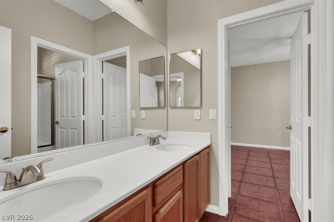 7308 Rustic Meadow Street Las Vegas, NV 89131 - Photo 13 of 27 Double vanity sinks and bright wood cabinetry complete this well-appointed bath.
