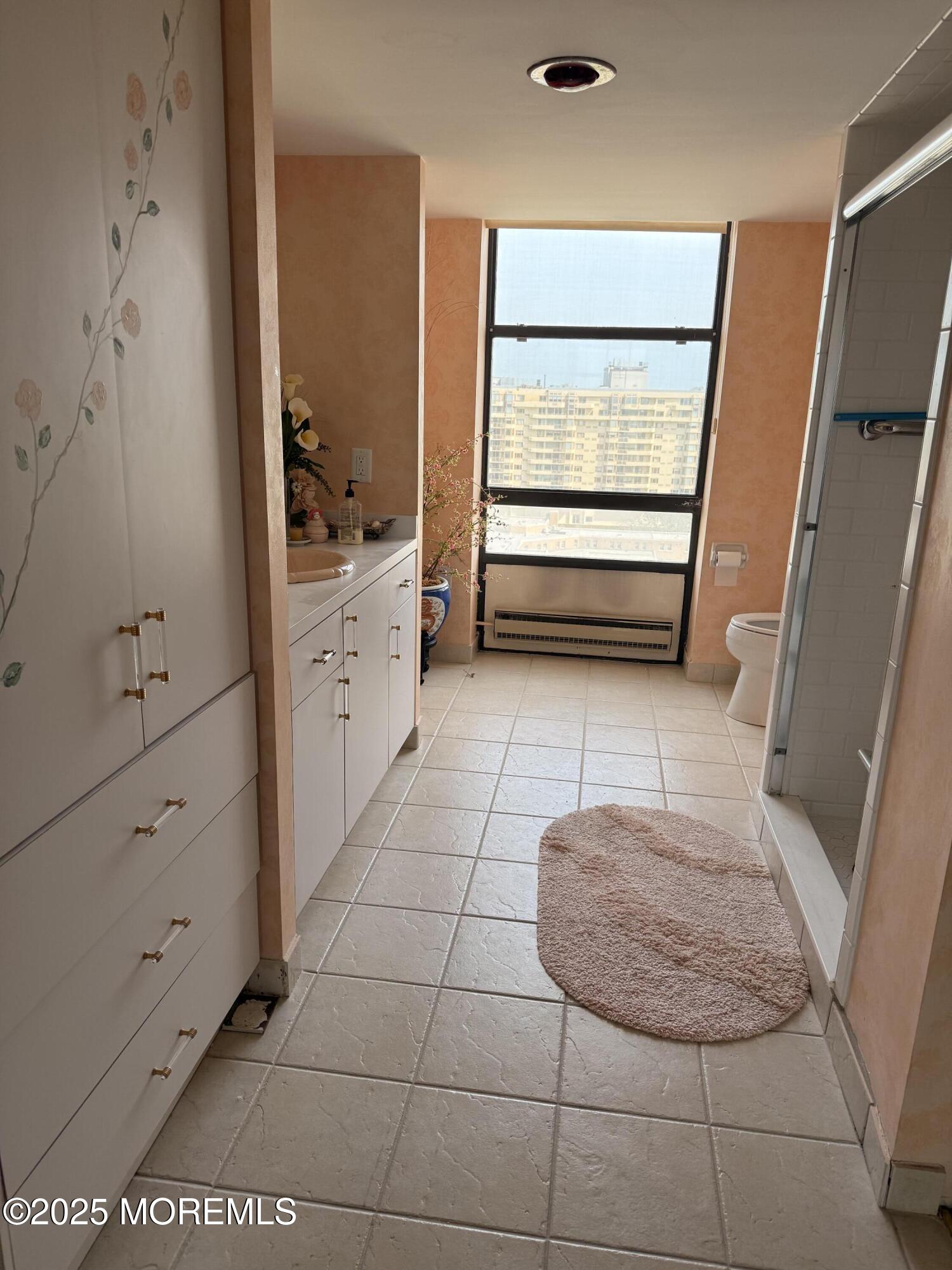 787 Ocean Avenue, Unit 1414 Long Branch, NJ 07740 - Photo 6 of 10 a bathroom with a sink a mirror and shower