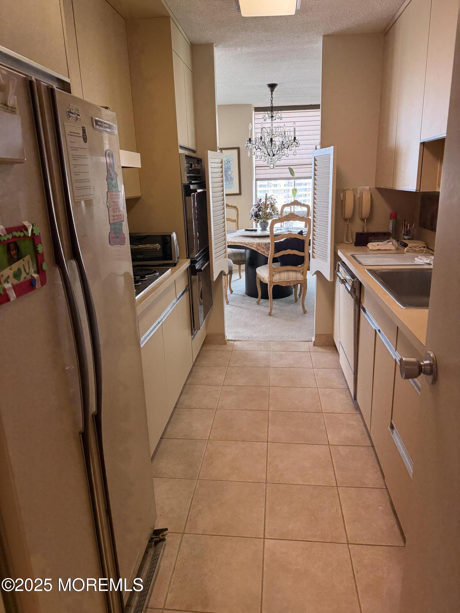 787 Ocean Avenue, Unit 1414 Long Branch, NJ 07740 - Photo 7 of 10 a kitchen with stainless steel appliances a refrigerator and a stove