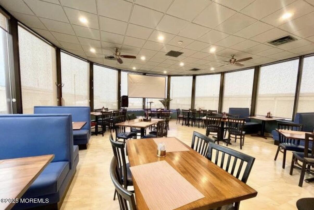 787 Ocean Avenue, Unit 1414 Long Branch, NJ 07740 - Photo 10 of 10 a living room with lots of furniture and a floor to ceiling window