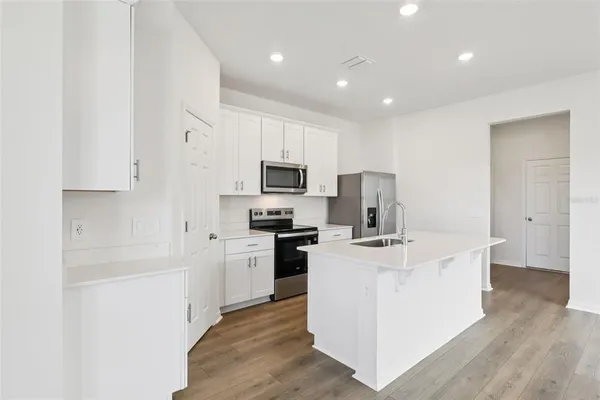a kitchen with a sink a stove and cabinets