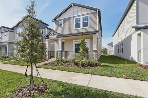 a front view of a house with a yard and potted plants