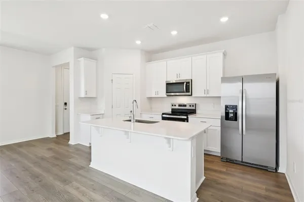 a kitchen with white cabinets and stainless steel appliances