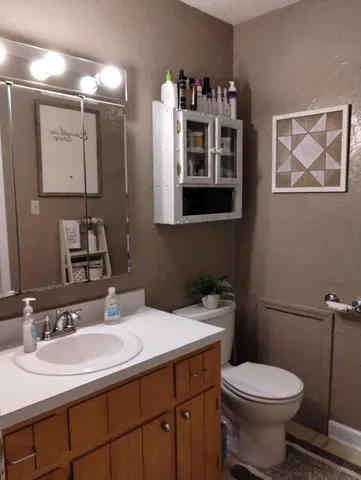 a bathroom with a sink toilet and mirror