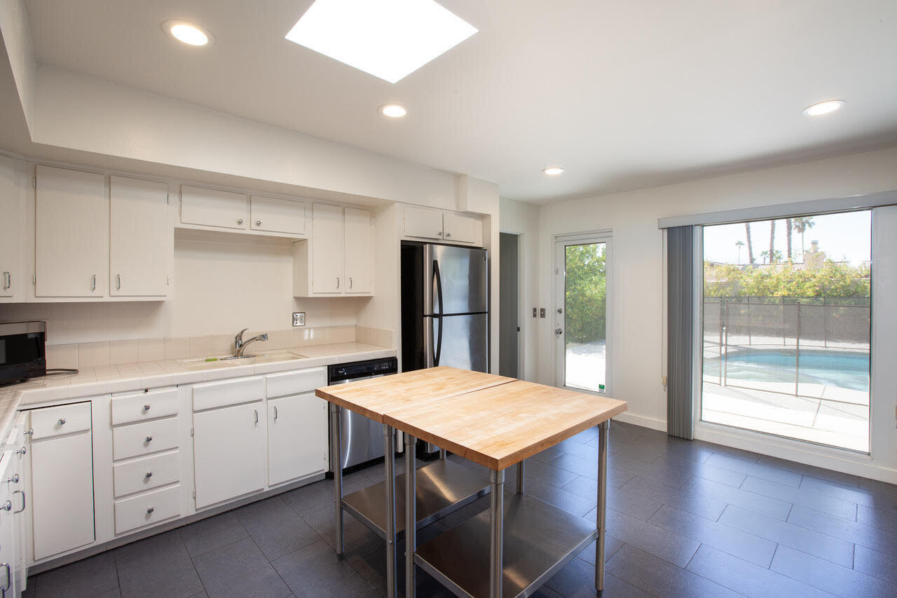 3033 East Verona Road Palm Springs, CA 92262 - Photo 22 of 23 a kitchen with a table chairs refrigerator and cabinets