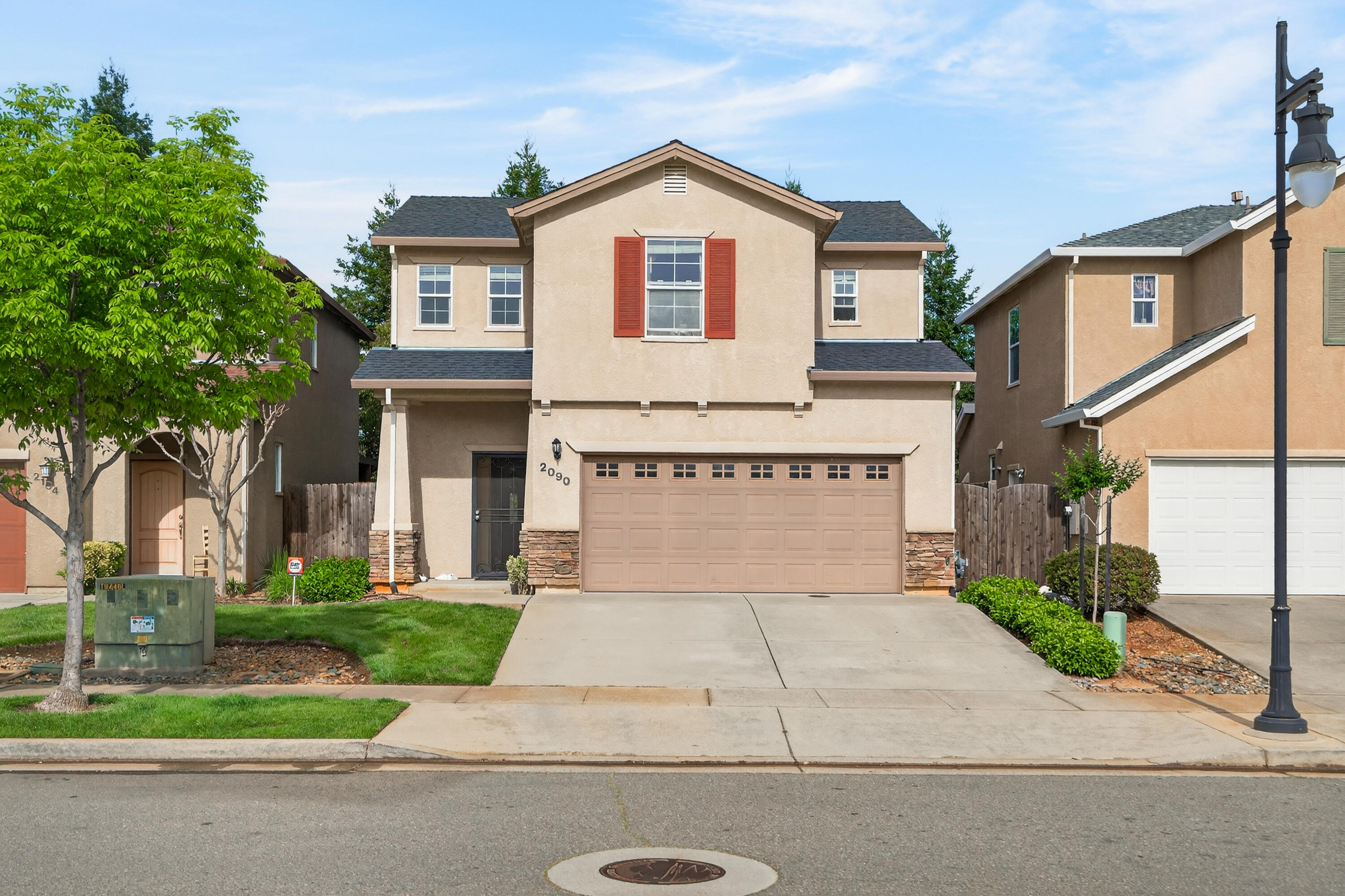 2090 Tuscany Way Redding, CA 96003 - Photo 2 of 37 a front view of a house with a yard and garage