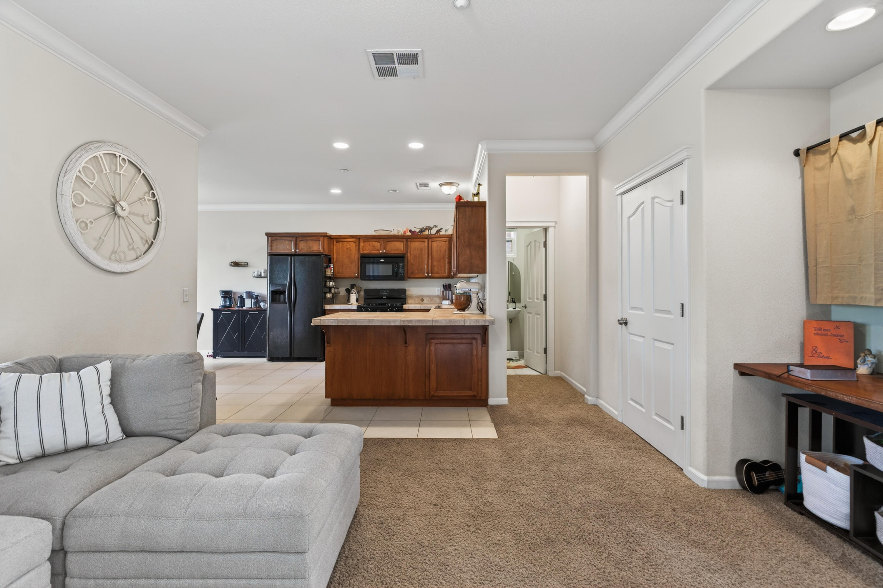 2090 Tuscany Way Redding, CA 96003 - Photo 8 of 37 a living room with furniture a kitchen view and a refrigerator