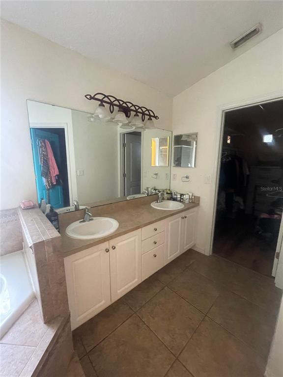 396 Kettering Road Deltona, FL 32725 - Photo 15 of 25 a spacious bathroom with a double vanity sink and a mirror