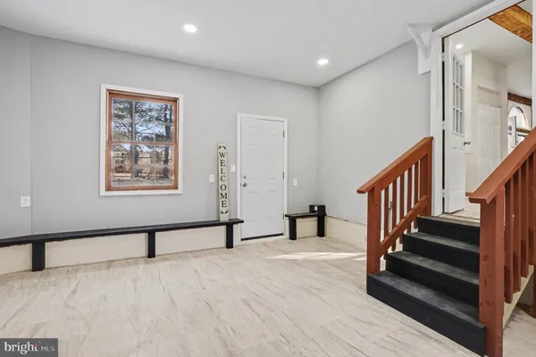 a view of an empty room with wooden floor and paintings on the walls