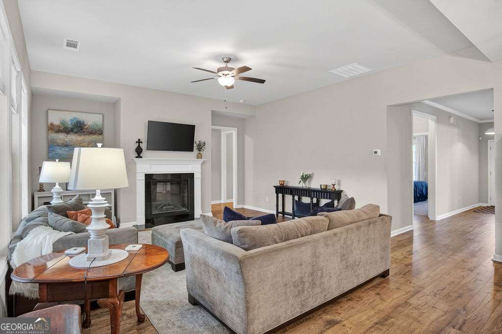 280 Greystone Court Winder, GA 30680 - Photo 23 of 40 a living room with furniture a fireplace and a flat screen tv