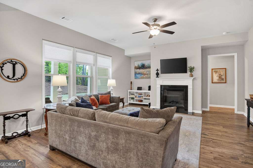 280 Greystone Court Winder, GA 30680 - Photo 24 of 40 a living room with furniture a fireplace and a flat screen tv