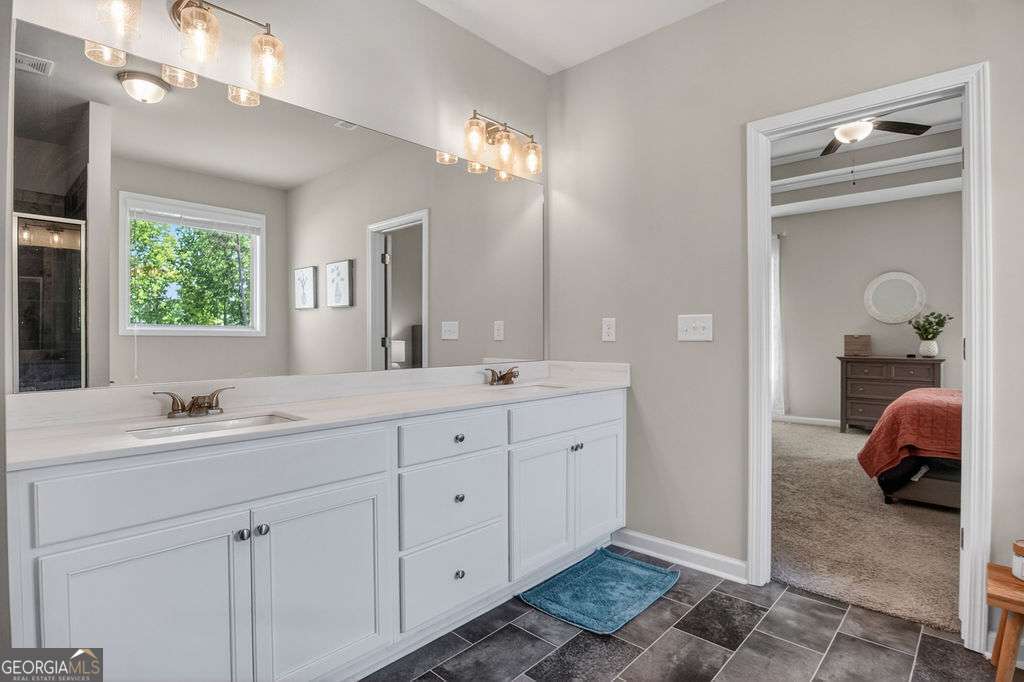 280 Greystone Court Winder, GA 30680 - Photo 28 of 40 a en suite bathroom with double sink and a mirror