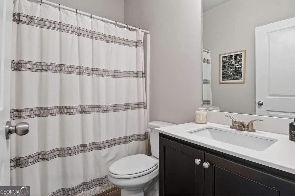 280 Greystone Court Winder, GA 30680 - Photo 9 of 40 a bathroom with a sink a toilet a mirror and shower