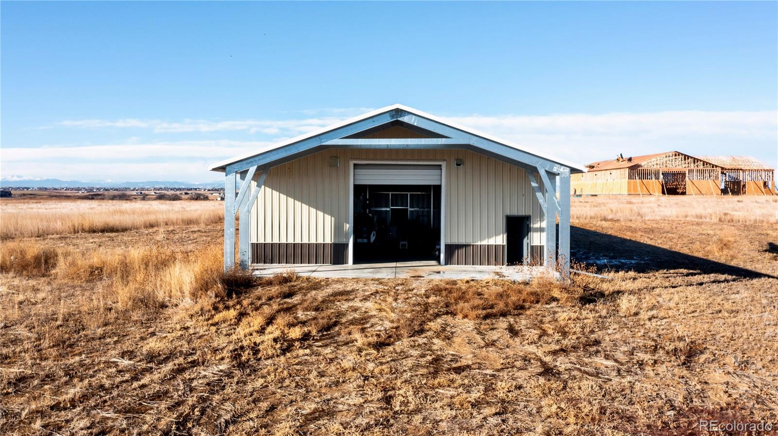 16590 Watkins Road Hudson, CO 80642 - Photo 12 of 30 a front view of a house with a yard and garage