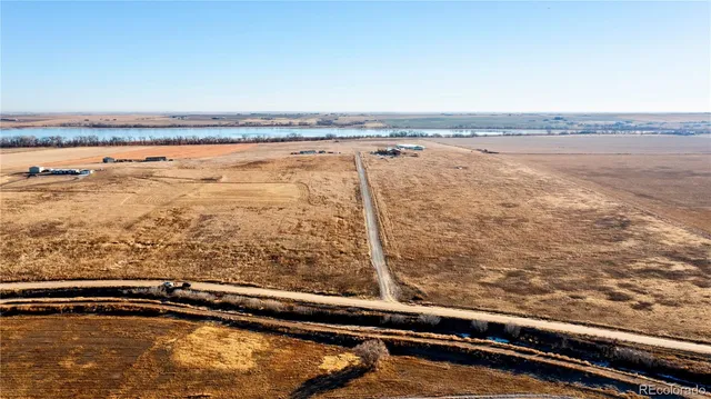 an aerial view of ocean and residential houses with outdoor space