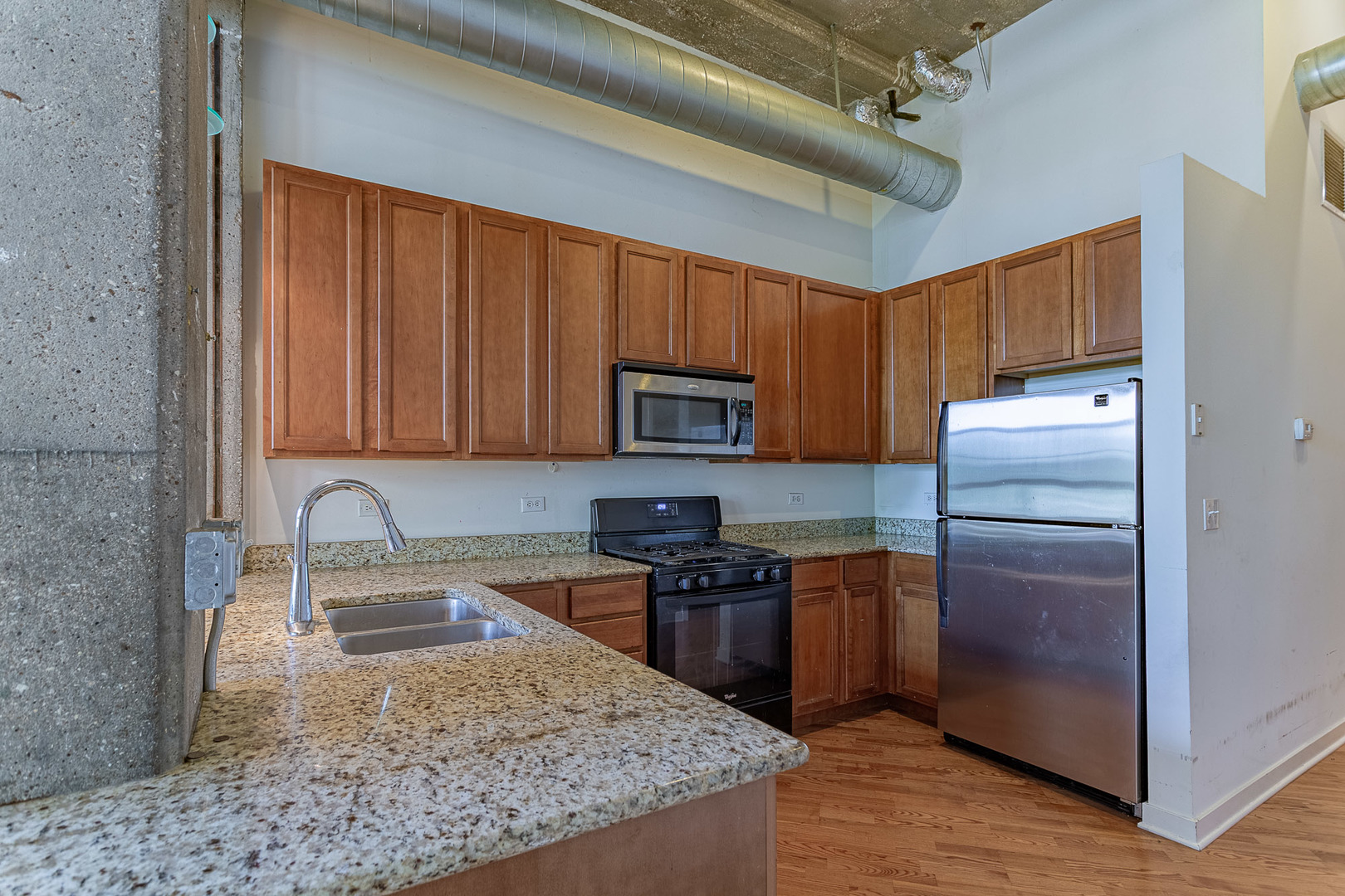 3963 West Belmont Avenue, Unit 117 Chicago, IL 60618 - Photo 3 of 13 a kitchen with stainless steel appliances granite countertop a sink stove and refrigerator