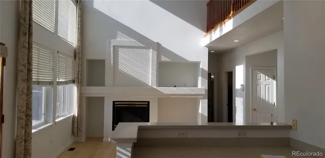 a view of a hallway with entryway and fireplace