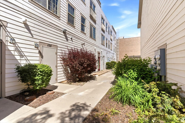 161 25th Street, Unit 6B Ogden, UT 84401 - Photo 17 of 20 Concrete walkway extending alongside the property, flanked by landscaping featuring established shrubs and varied plantings