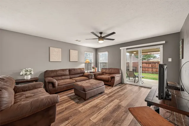 a living room with furniture flat screen tv and a large window