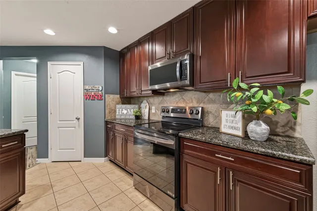 a kitchen with stainless steel appliances granite countertop a stove a sink and a microwave