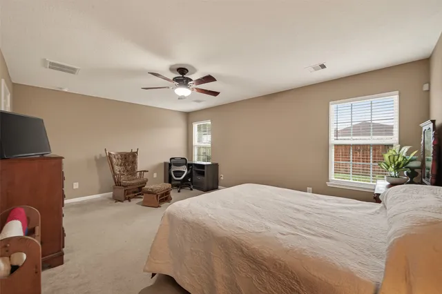a spacious bedroom with a bed and a chandelier