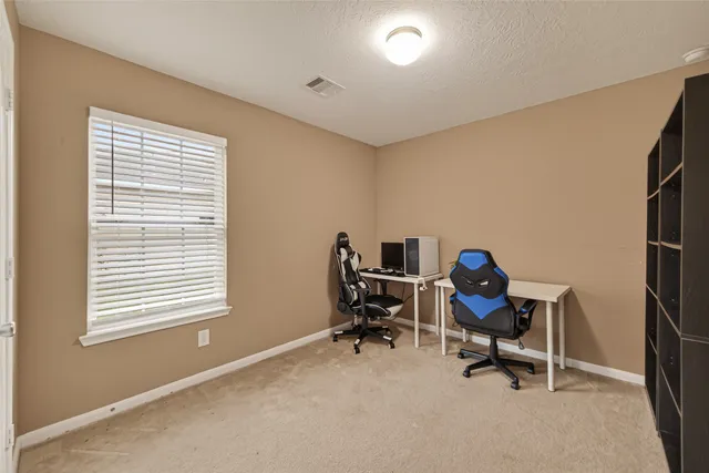 a view of a workspace with furniture and a window