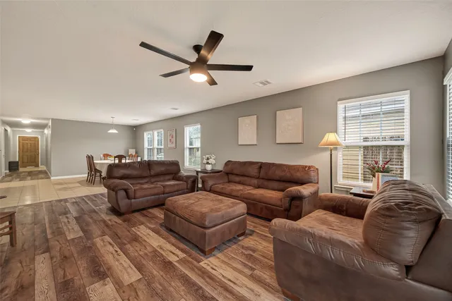 a living room with couches and a large window with rug floor