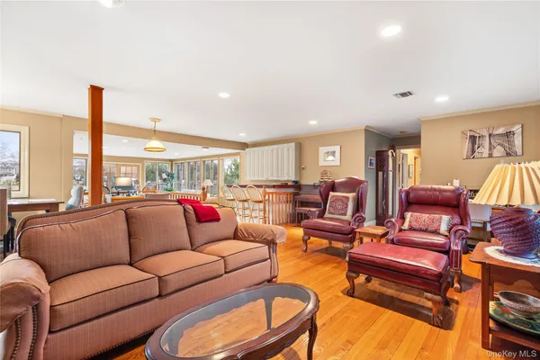 a living room with furniture kitchen view and a large window