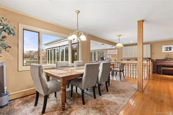 a dining room with furniture wooden floor a chandelier and a rug