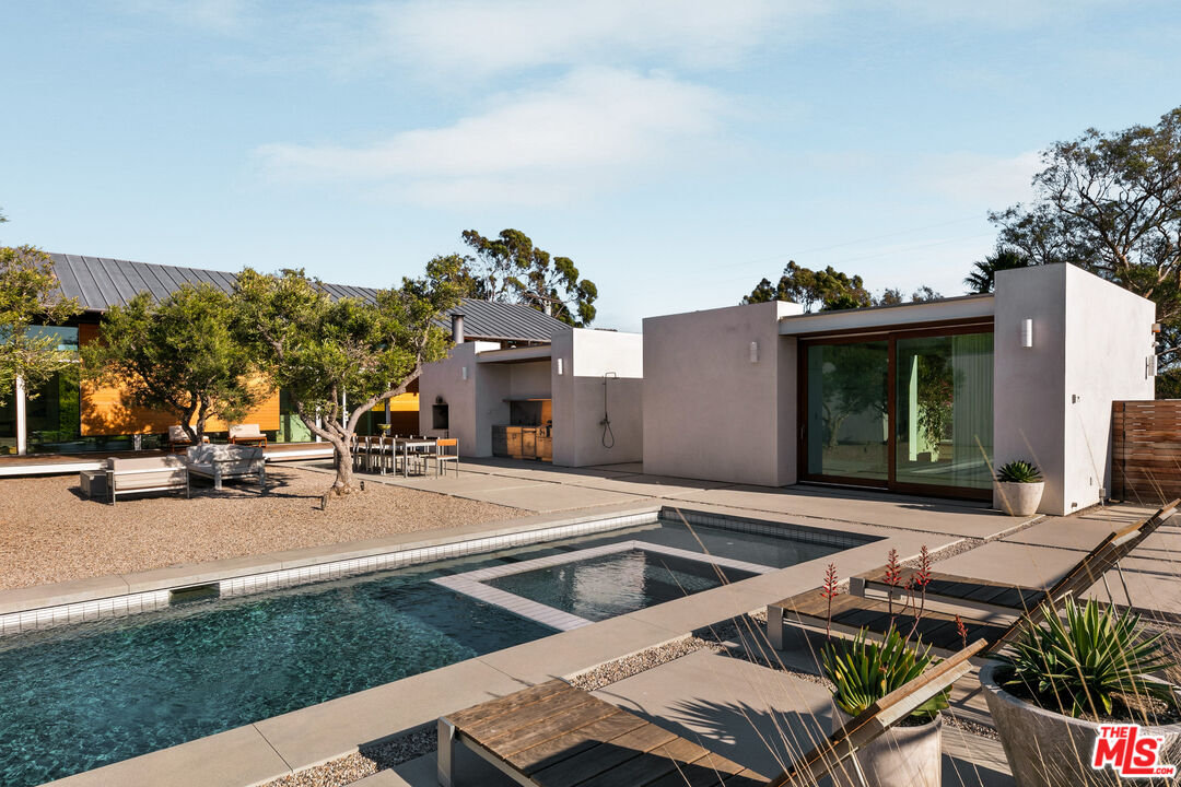 6728 Wildlife Road Malibu, CA 90265 - Photo 46 of 57 a view of a patio with swimming pool table and chairs